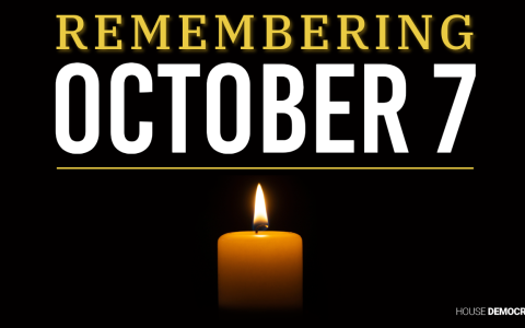 a lit candle against a black background with text reading remembering october 7