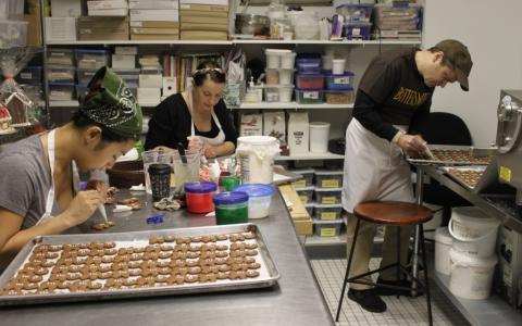 Rep. Quigley decorates gingerbread man cookies alongside Bittersweet Pastry Shop employees.