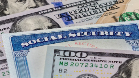 a close up shot of social security cards and $100 bills layered over each other