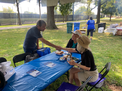 quigley shakes hands with seated seniors at a picnic