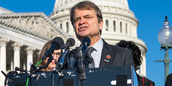 Quigley stands at podium. Text sys "Quigley calls for dismantling ICE, Congressman shifts position following endless ICE abuses."
