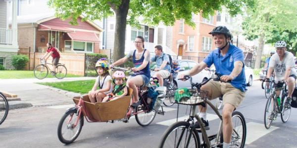 Rep Quigley rides a bike with a group of other cyclists