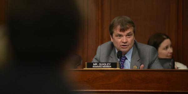 Mike Quigley sits at a dias in a committee room