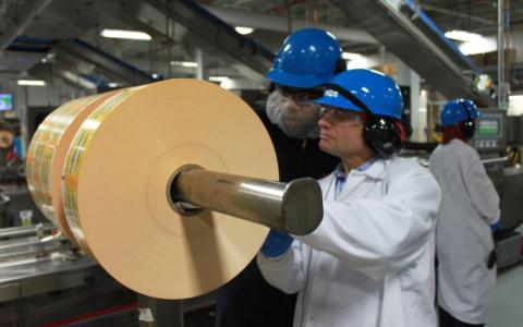 Rep. Quigley learns about the packaging process at Nestlé from a Franklin Park facility employee.