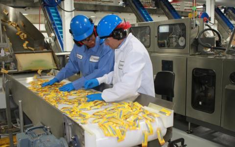 Rep. Quigley checks packaging quality of BUTTERFINGER® candy bars with a Nestlé employee.