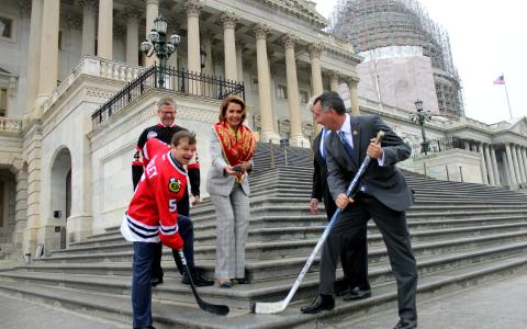 Rep. Quigley (left) and Rep. Jolly (right) face off on the Capitol steps as House Minority Leader Nancy Pelosi drops the puck.