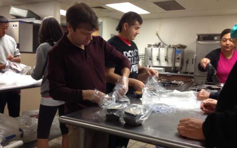 U.S. Rep. Mike Quigley ties off a plastic bag with a hot meal. The meal will then be deliver to a senior in the west suburbs as part of the Meals on Wheels program. | Mark Lawton/Sun  Times Media